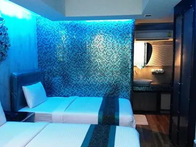 a blue room with a bed and a bathroom at Blutique Hotel in Bangkok