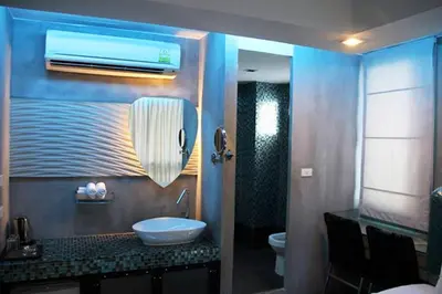 a bathroom with a sink and a toilet and a mirror at Blutique Hotel in Bangkok