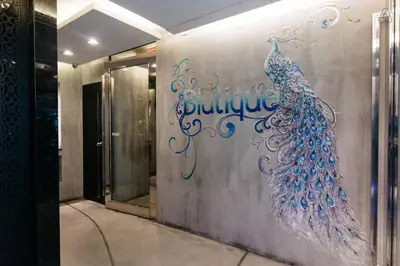 a wall with a peacock painting on it in a building at Blutique Hotel in Bangkok