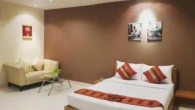 a hotel room with a bed and a chair at Sena House in Bangkok