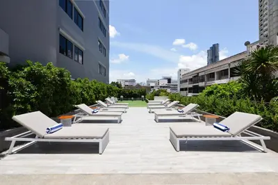 a row of chaise lounges are lined up on a sidewalk at Oakwood Hotel & Residence Bangkok in Bangkok