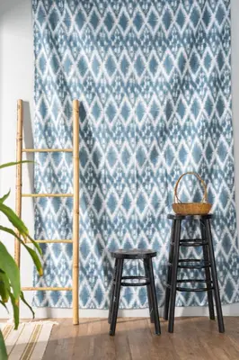 a pair of stools in front of a blue wallpaper at Better Moon Guesthouse in Bangkok