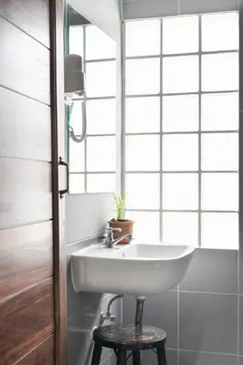 a white sink in a bathroom with a window at Better Moon Guesthouse in Bangkok