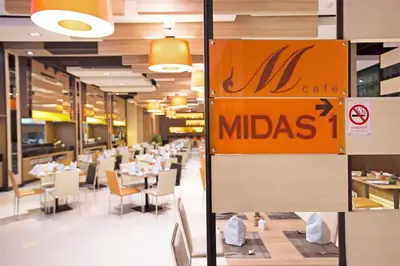 a restaurant with tables and chairs and a mitzacs sign at Mida Hotel Ngamwongwan - SHA Plus in Nonthaburi