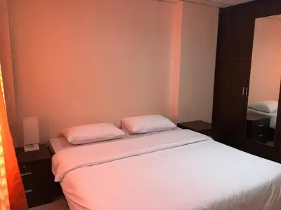 a bedroom with two beds with white sheets and pink pillows at De Junction House in Bangkok