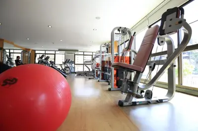 a gym with a large red ball and weights at De Junction House in Bangkok