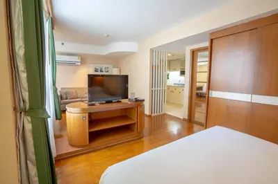 a living room with a television and a couch at AT EASE saladaeng by AETAS in Bangkok