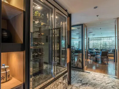 a restaurant with glass doors and a dining room at Arcadia Suites Ploenchit Bangkok in Bangkok