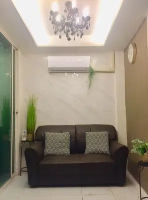 a brown couch in a living room with a ceiling at R9 Bangkok in Bangkok