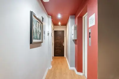 a hallway with red walls and a door at The Richy Place Guest House in Bangkok
