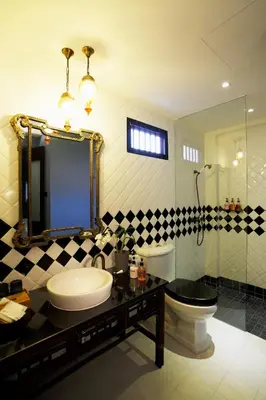 a bathroom with a sink and a toilet and a mirror at Baan Chart in Bangkok