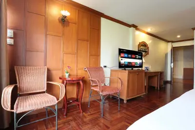 a room with chairs and a table and a tv at Royal Ivory Sukhumvit Nana in Bangkok