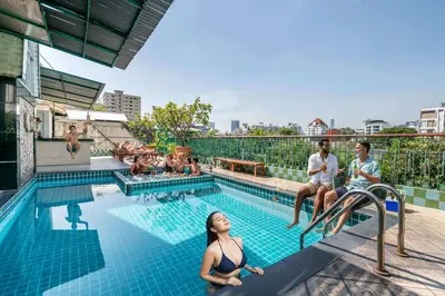 a group of people sitting around a swimming pool at Royal Ivory Sukhumvit Nana in Bangkok
