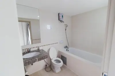 a bathroom with a sink and a toilet and a mirror at So good Hotel Bangkok in Bangkok
