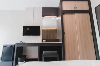a bedroom with a desk and a mirror at So good Hotel Bangkok in Bangkok