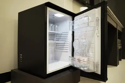 an open refrigerator with bottles of water in it at So good Hotel Bangkok in Bangkok