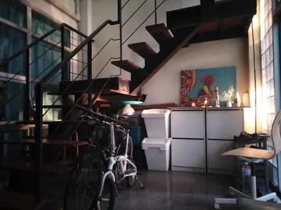 a bike parked in a room with a spiral staircase at NBH.@ Prannok in Bangkok