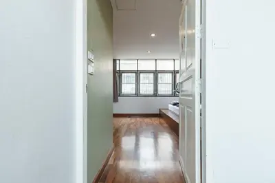 an empty room with a hallway with a refrigerator at 99 Hostel Khaosan in Bangkok