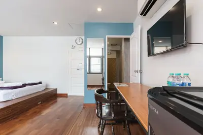 a room with a table and a tv on the wall at 99 Hostel Khaosan in Bangkok