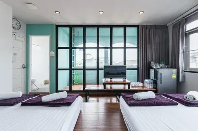 two beds in a room with a living room at 99 Hostel Khaosan in Bangkok