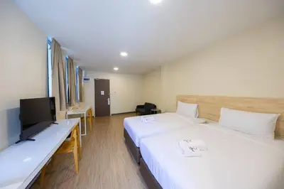 a hotel room with two beds and a flat screen tv at Fine Bed Hotel in Nonthaburi