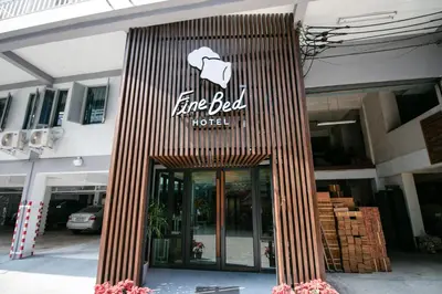 a building with a line bed hotel sign on it at Fine Bed Hotel in Nonthaburi