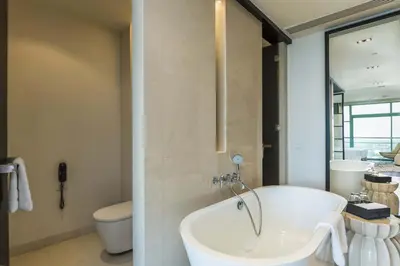 a bathroom with a bath tub and a toilet at Chatrium Hotel Riverside Bangkok in Bangkok