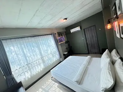 a bedroom with a large bed and a window at BB House Rambuttri2 บีบี เฮ้าส์ รามบุตรี2 in Bangkok