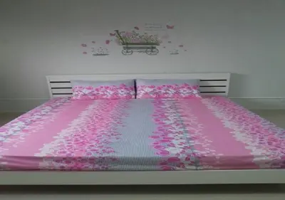 a bed with a pink bedspread and pink flowers on it at T8 IMPACT BANGKOK Thailand in Bangkok