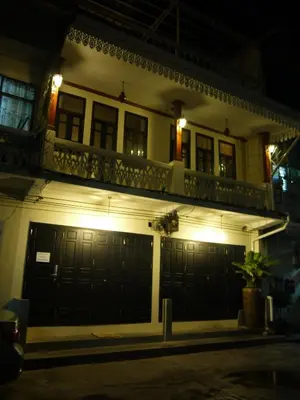a house with two garage doors at night at The Royal ThaTien Village in Bangkok