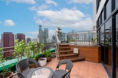 a balcony with chairs and tables on a building at Grand Diamond Suites Hotel in Bangkok