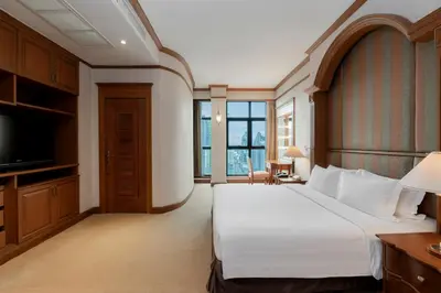 a hotel room with a large bed and a television at Grand Diamond Suites Hotel in Bangkok
