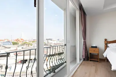 a bedroom with a balcony with a view of a city at Royale 8 Ville Guest House in Bangkok