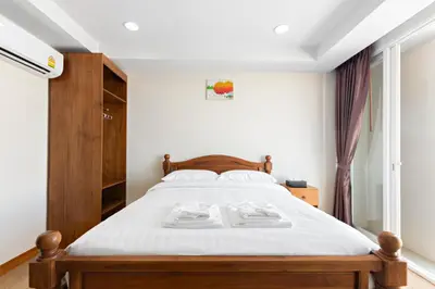 a bedroom with a large bed with white sheets at Royale 8 Ville Guest House in Bangkok
