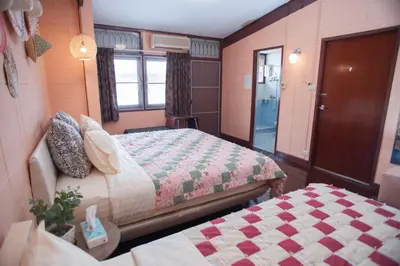 a small bedroom with two beds and a window at Dunah's Garden Home in Bangkok