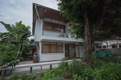 a house with a tree in front of it at Dunah's Garden Home in Bangkok