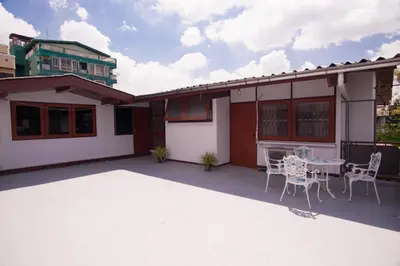 a patio of a house with a table and chairs at Dunah's Garden Home in Bangkok