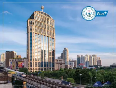 a tall building in front of a city at Emporium Suites by Chatrium in Bangkok