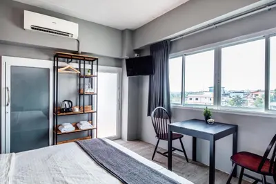a bedroom with a desk and a bed and a desk and chair at Penyos Service Apartment in Bangkok