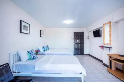 a hotel room with two beds and a desk at Penyos Suite in Bangkok