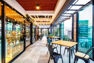 a restaurant with tables and chairs and windows at Penyos Suite in Bangkok