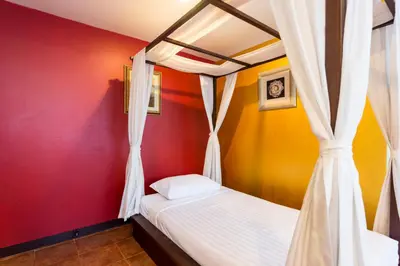 a bedroom with a bed and a red wall at The Best Bangkok House in Bangkok