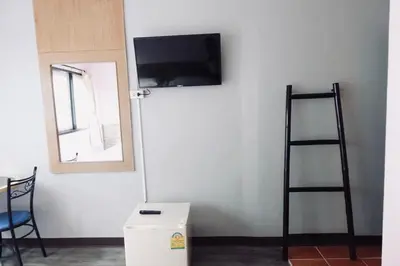 a room with a wall with a tv and a ladder at Rajparop PLace in Bangkok