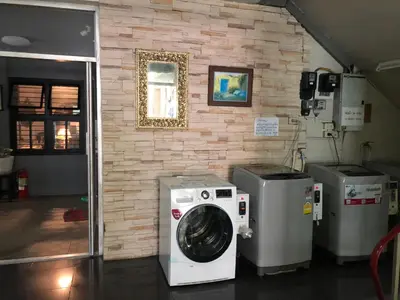 a washer and dryer in a room with a brick wall at Rajparop PLace in Bangkok