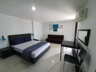 a bedroom with a bed and a couch and a mirror at @Room Apartment in Bangkok