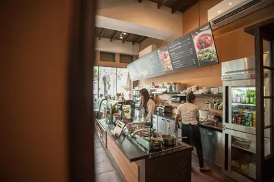 two people preparing food in a restaurant kitchen at Chetuphon Gate in Bangkok