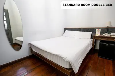 a bedroom with a bed with a mirror and a sink at Chetuphon Gate in Bangkok
