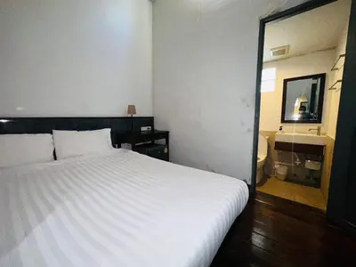 a bedroom with a white bed and a mirror at Chetuphon Gate in Bangkok