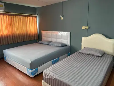 a bedroom with two beds and a window at Dailyroom C3,C4by Anna in Nonthaburi