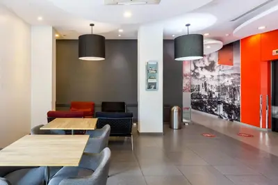 a dining room with two tables and chairs at Easy Planet Bangkok Asoke in Bangkok
